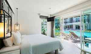 Hotellrum med bäddad säng och utsikt över en pool utanför. (AI-genererad text)