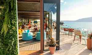 En solig terrass med sittmöbler och havsutsikt. (AI-genererad text)