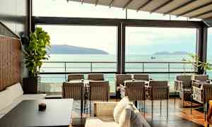 Uteplats med sittmöbler med utsikt över havet och öar. (AI-genererad text)