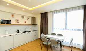 Ett modernt kök och matsalsområde med ljusa möbler och stora fönster. (AI-genererad text)