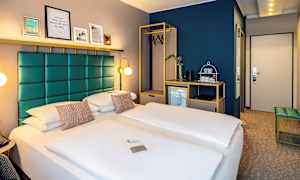 Hotellrum med en dubbelsäng, modern inredning och en garderob med hängare. (AI-genererad text)