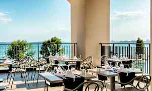 En terrass med dukade bord och utsikt över havet. (AI-genererad text)