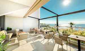 Ljus sittgrupp med utsikt över havet. (AI-genererad text)