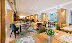 Bild av en restaurang med bord, stolar och dekorationer. (AI-genererad text)