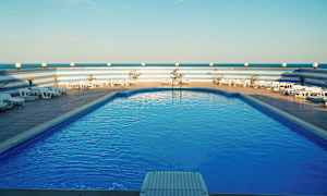 Pool med solstolar och blå himmel. (AI-genererad text)