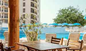 Bild av ett hotellområde med en pool, solstolar och parasoller. (AI-genererad text)
