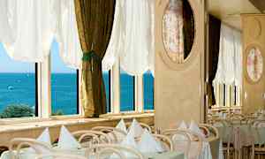 Restaurang med dukade bord vid fönster med utsikt över havet. (AI-genererad text)