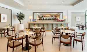 Modern bar med eleganta bord och stolar i en ljus interiör. (AI-genererad text)