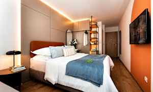 Modernt hotellrum med dubbelsäng, dekorativa kuddar och belysning. (AI-genererad text)