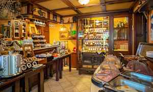 En inredning av en restaurang eller café med ett buffébord och vinflaskor i en hylla. (AI-genererad text)