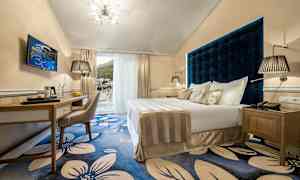 Hotellrum med dubbelbädd och blå blommigt golv. (AI-genererad text)