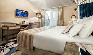 Modern hotellrum med dubbelsäng, skrivbord, stol och TV. (AI-genererad text)