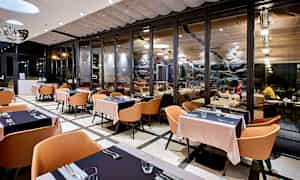 Restaurang med modern inredning och stora glaspartier. (AI-genererad text)