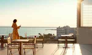 Person på en terrass med utsikt över havet. (AI-genererad text)