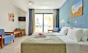 Ett hotellrum med en säng, sittgrupp och en balkong. (AI-genererad text)