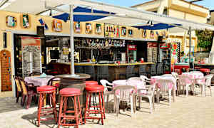 En utomhusservering med bord, stolar och en bar. (AI-genererad text)