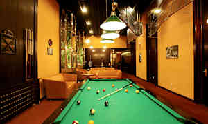 Spelrum med biljardbord, soffor och konstnärlig inredning. (AI-genererad text)