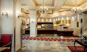 Hotellreception med marmorgolv, kristallkronor och ett elegant inrett område. (AI-genererad text)