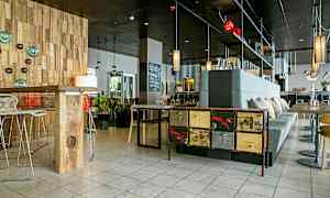 Ett modernt café eller restaurang med designad inredning, trädetaljer och stilfull belysning. (AI-genererad text)
