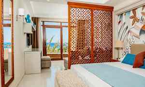 Hotellrum med säng, dekorativ träpanel och utsikt mot havet. (AI-genererad text)