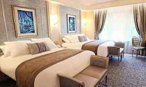 Lyxigt inrett hotellrum med två dubbelsängar, eleganta möbler och väggdekorationer. (AI-genererad text)