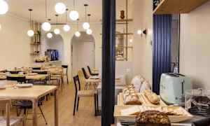 En matsal med bord, stolar och en buffé med bröd och tillbehör. (AI-genererad text)