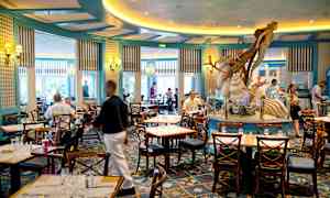 En restaurang med sittplatser och en dekoration i form av en havsfigur i mitten. (AI-genererad text)