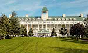 Bild på en stor byggnad med en gräsmatta i förgrunden. (AI-genererad text)