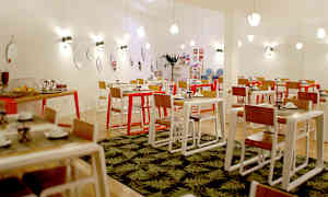 En bild på en ljus och modern matsal med plattor och ljusa trämöbler. (AI-genererad text)