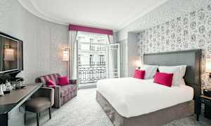 Ett hotellrum med en stor säng, rosa kuddar och en balkong. (AI-genererad text)