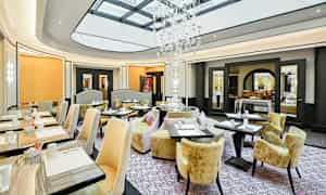 En elegant restaurang med stora fönster och en fantastisk kristallkrona. (AI-genererad text)