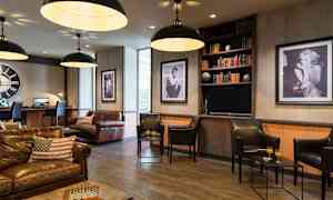 En stilfull lounge med lädermöbler och konst på väggarna. (AI-genererad text)