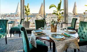 Restaurang med elegant dukning och utsikt över staden. (AI-genererad text)