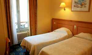 Ett hotellrum med två enkelsängar, en tavla på väggen och ett fönster med gardiner. (AI-genererad text)