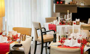 Restaurangbord med juldekorationer, dukade med servetter och glas. (AI-genererad text)