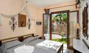 Ett sovrum med två sängar, dekorerat med textilier, väggkonst och en öppen dörr som vetter mot en trädgård med palmer. (AI-genererad text)