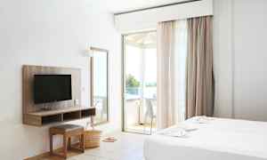 Ett hotellrum med två sängar, en TV, en spegel och en balkong. (AI-genererad text)