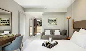 Ett hotellrum med en säng, en soffa och ett skrivbord. (AI-genererad text)