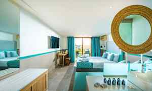 Ett modernt hotellrum med dubbelsäng, blå detaljer och ett stort fönster ut mot balkongen. (AI-genererad text)