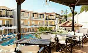 Hotellbyggnad med balkonger och parasoll vid poolen, med sittgrupper i förgrunden. (AI-genererad text)