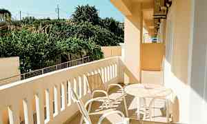 En balkong med trädgårdsutsikt, möblerad med bord och stolar. (AI-genererad text)