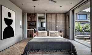 Moderna sovrum med stor säng och öppen glasfasad som vetter mot uteplats. (AI-genererad text)