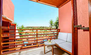 Uteplats med sittplats och bord mot solig utsikt. (AI-genererad text)