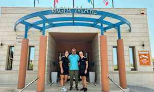 Ingången till byggnaden med skyltar och flaggor ovanför. (AI-genererad text)