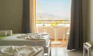 Ett hotellrum med två bäddar och en möblerad balkong med utsikt. (AI-genererad text)