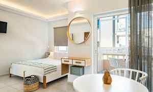 Modernt inrett hotellrum med säng, spegel och balkongdörr. (AI-genererad text)