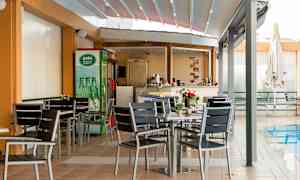 En utomhusservering med bord och stolar vid en pool. (AI-genererad text)