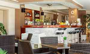 En bar med höga stolar och bord framför. (AI-genererad text)