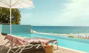 Solstolar vid en pool med havsutsikt. (AI-genererad text)