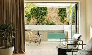 Modernt rum med sittgrupp och utsikt över privat pool och vägg med klätterväxt. (AI-genererad text)